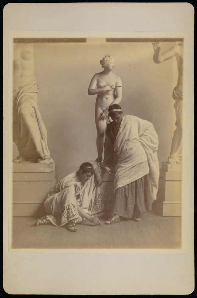 (To mannlige studenter i gresk kostyme før et gipsavstøpning av Afrodite i kammeret i pennen ... av Thomas Eakins