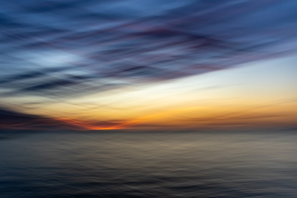 En eterisk solnedgang over havet av Franco Tessarolo