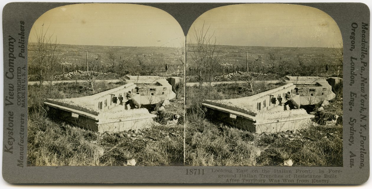 Horisontalt, sepia stereokort som viser en uniformert mann som står bak et sett med betonggraver i et åpent felt. Keystone Stereograf nummer 18711. Tittelen lyder av Keystone View Company