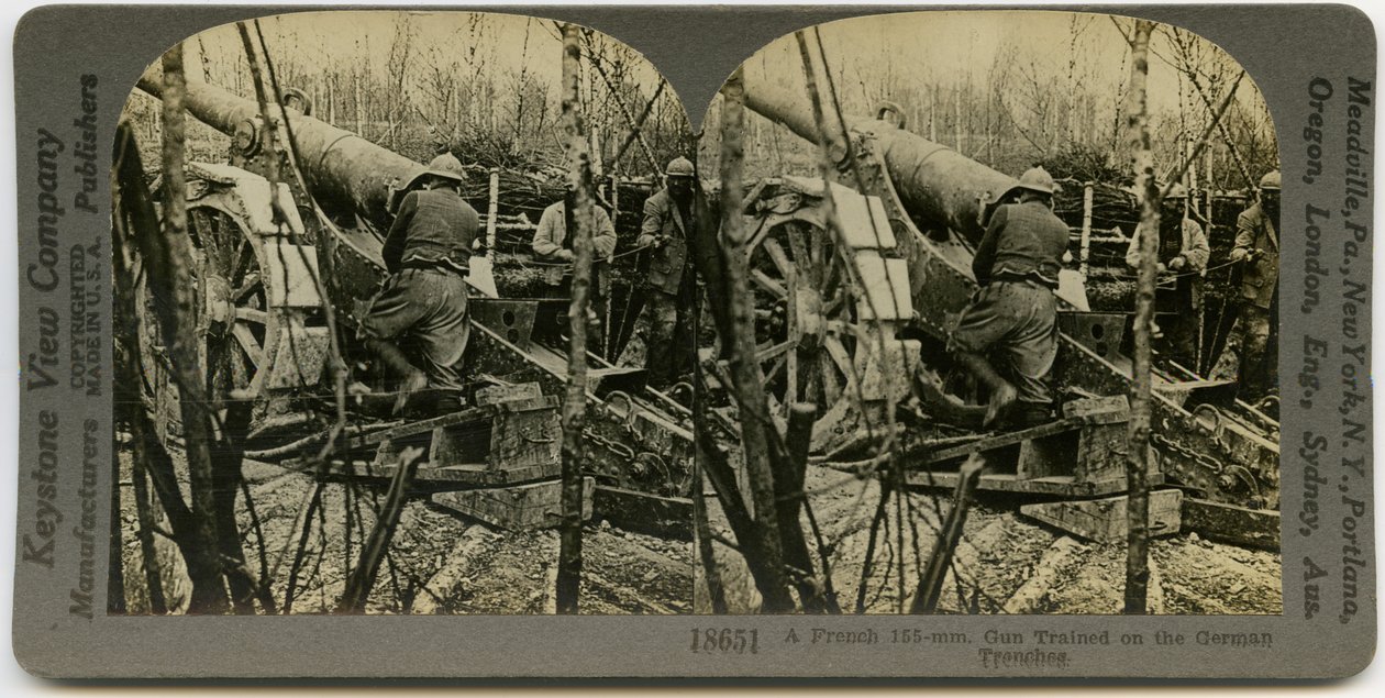 Horisontalt sepia -stereokort som viser tre uniformerte franske soldater som jobber med en 155 mm feltartilleripistol. Keystone stereografnummer 18651 av Keystone View Company