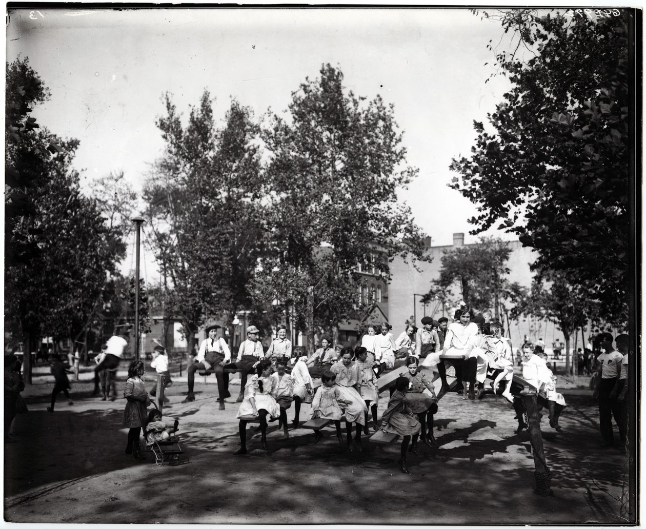 Horisontalt, svart -hvitt fotografi som viser barn som leker på vipper i en uidentifisert park av Unknown
