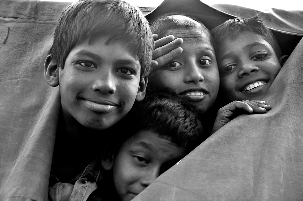 Nødløse barn ser gjennom et revet lerret av en politibil i byen Dhaka, Bangladesh. 26. november 2006. av Unknown
