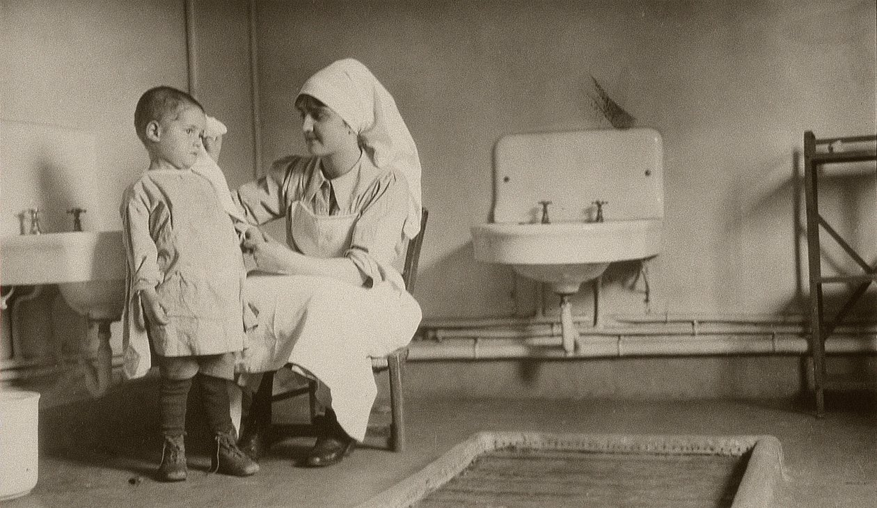 Sykepleier som pleier et sykt barn ved Passay og Saint-Quentin-koloniene for flyktninger og foreldreløse, 1919 av American Photographer