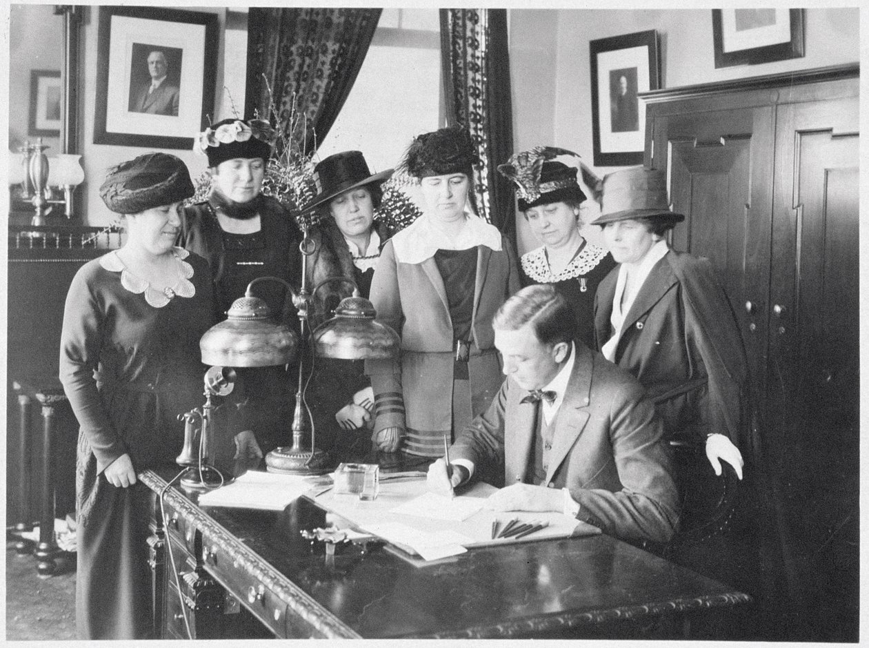 Guvernør Carl Elias Milliken signerer stemmerettsloven mens seks kvinner ser på, 1917 av American Photographer