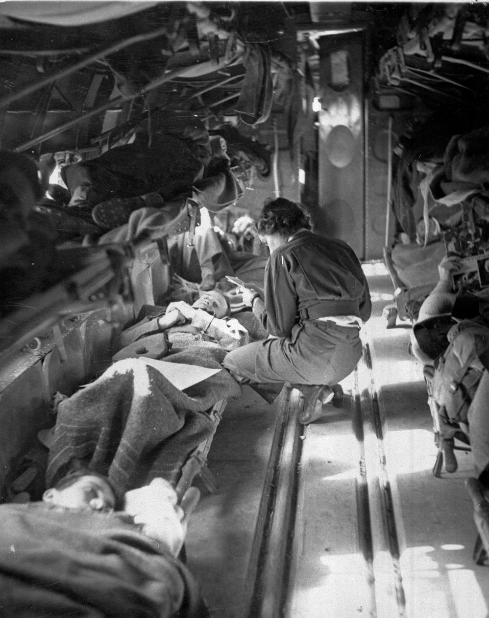 Miss Mary Smith fra South Carolina behandler pasienter under flukt til Nord-Afrika, ca. 1943-45, fra en samling av 650 fotografier satt sammen av Commando Association av American Photographer