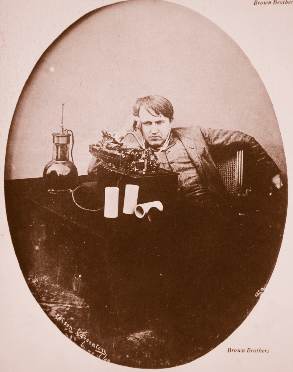 Thomas A. Edison sitter ved sin forbedrede maskin, 1889 (sepia-bilde) av American Photographer
