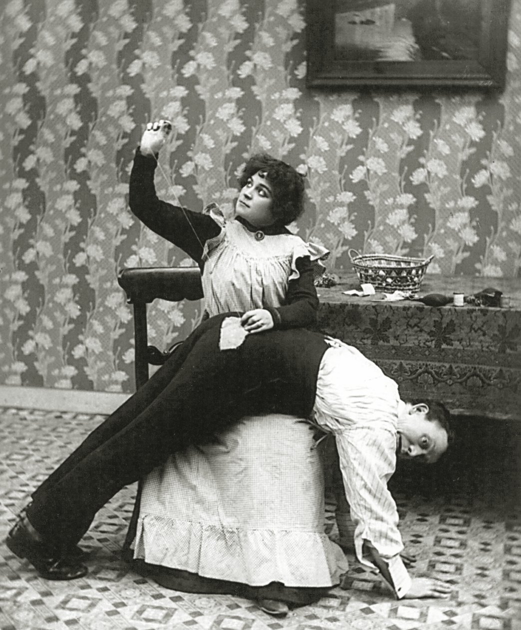 Kvinne som syr en rift på en manns bukse, ca. 1895 av American Photographer