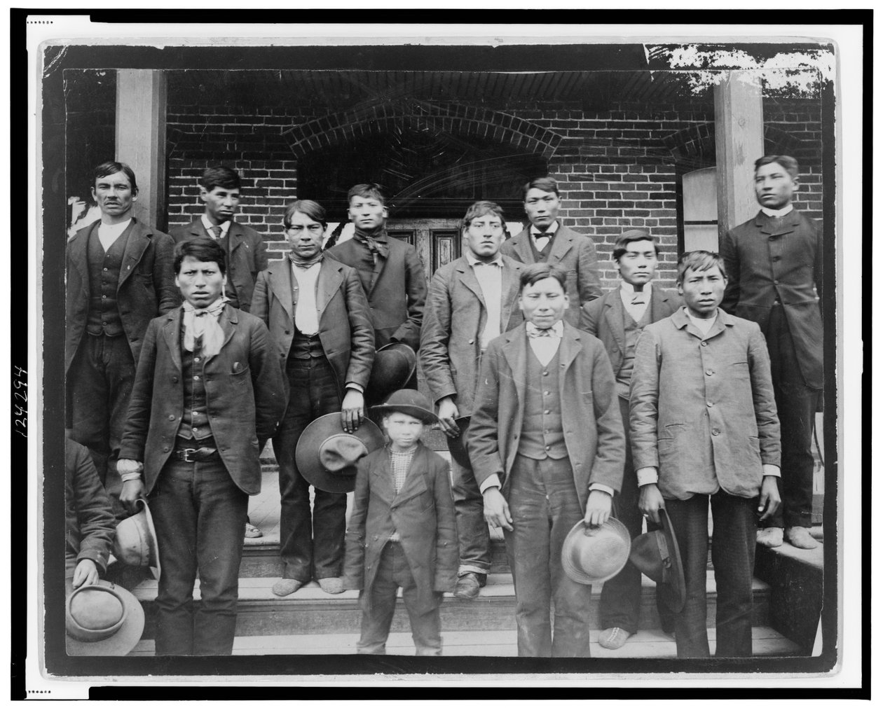 Indianske menn og en gutt poserte utenfor Carlisle Indian School, Pennsylvania, ca. 1890 (s/hvitt-bilde) av American Photographer