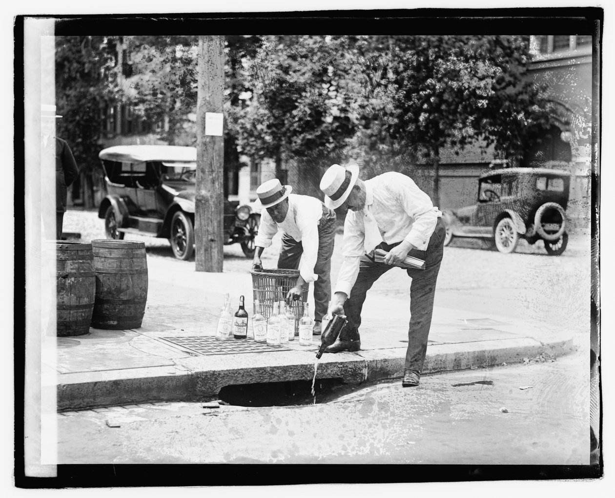 To menn som heller brennevin i stormavløpet, 8. juli 1921 (s/hvitt-bilde) av American Photographer