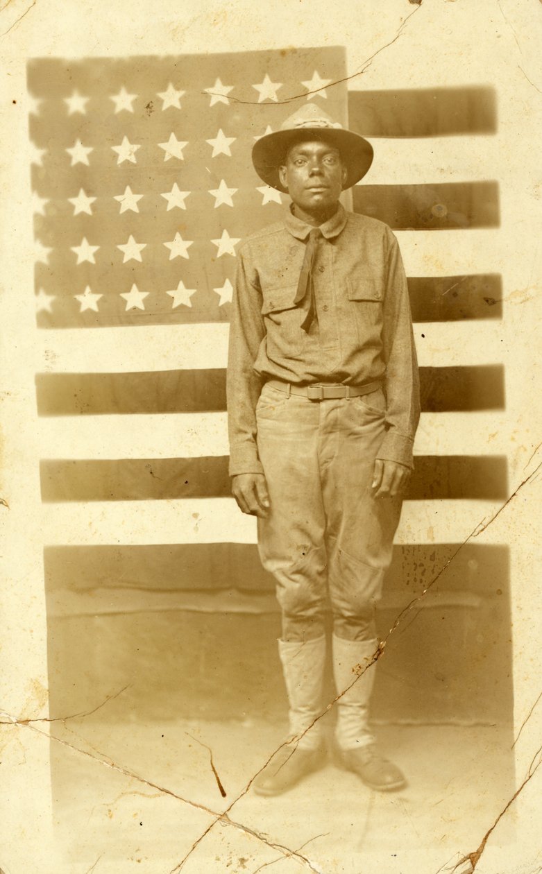 Soldat fra første verdenskrig med amerikansk flagg i bakgrunnen, 1914-18 av American Photographer