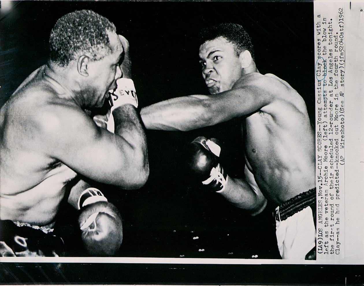 Unge Cassius Clay scorer med venstre mot veteranen Archie Moore i første runde av kampen i Los Angeles av American Photographer