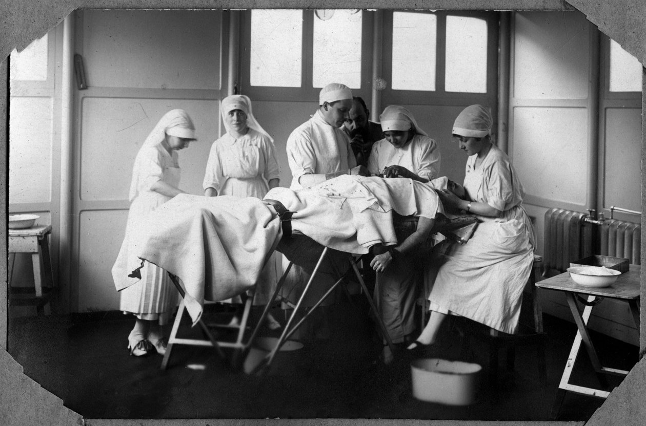 Første verdenskrig 1914-1918: leger og sykepleiere ved det røde kors (Therese Pavillou? ) behandler en soldats sår som sover i kloroform i leiren Couville i Manche, Basse-Normandie (Nedre-Normandie), Frankrike. Anonym fotografering av Anonymous Anonymous