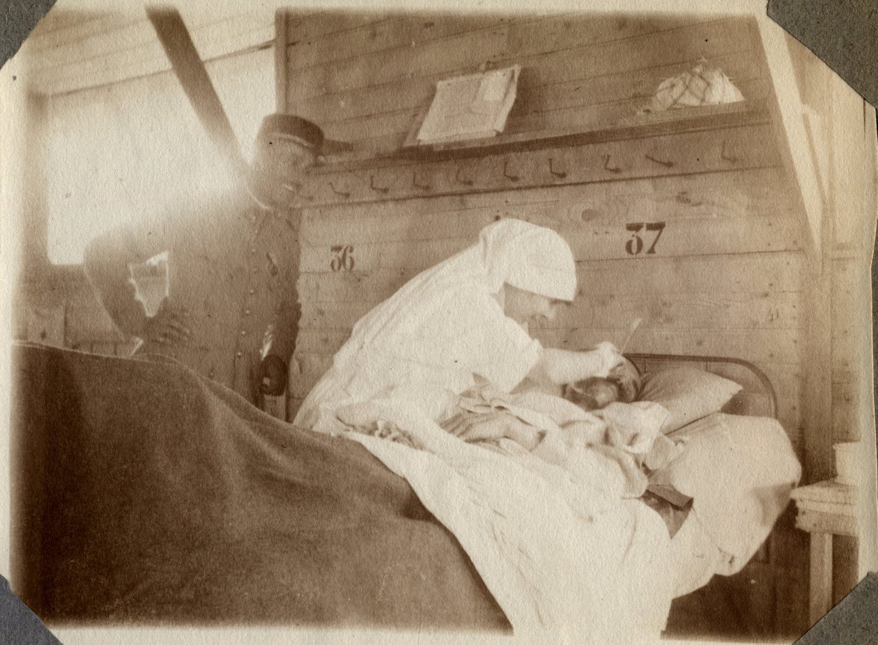 Første verdenskrig 1914-1918: sykepleier i bluse barberer en soldat (franske krigssår ligger i en seng), i Couville, Manche, Basse-Normandie (Nedre-Normandie), Frankrike. Anonymt fotografi juli 1917. Privat samling, Stella. av Anonymous Anonymous