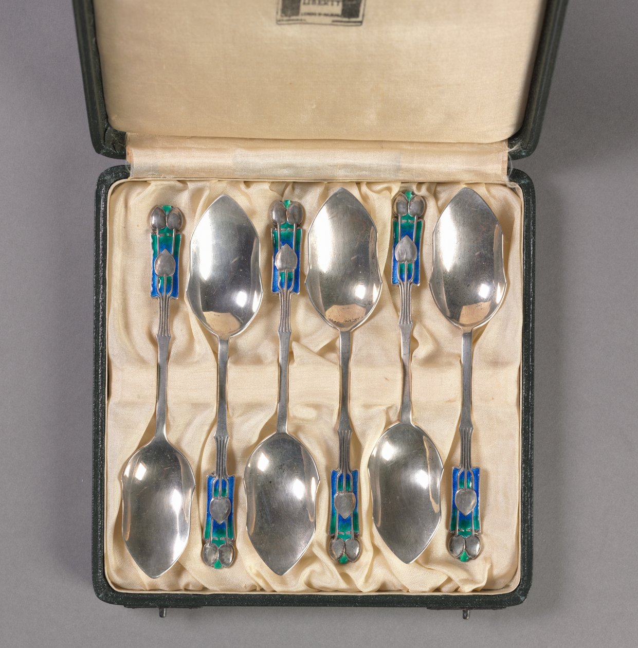 Sett med seks skjeer i original eske, produsent Liberty and Company, ca. 1895-1910 av Archibald Knox