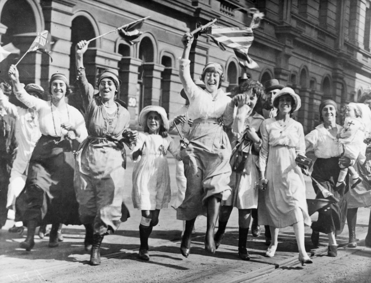 En gruppe kvinner og barn gleder seg i en gate i Sydney ved undertegnelsen av våpenhvilen, 11. november 1918 av Australian Photographer