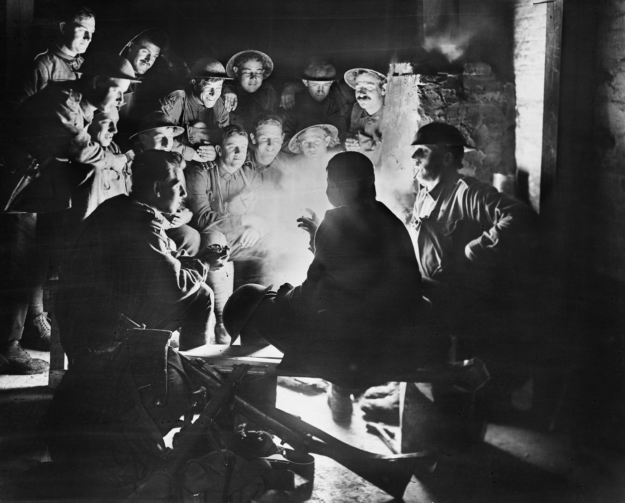 Medlemmer av 1st Australian Light Trench Mortar Battery, 1st Australian Division lytter til det siste fra en av kameratene deres rundt en brann i en utgravd billett i Ypres, 28. oktober 1917 (bw pho av Australian Photographer