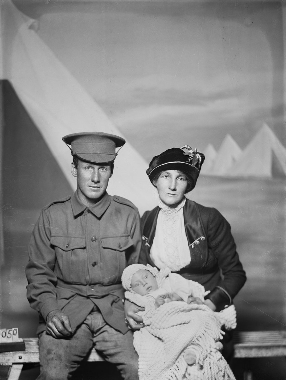 Studioportrett av 1159 Private (Pte) George Beamish Swanton, australsk 24. bataljon, fra Werribee, Victoria, med sin kone Nellie og den unge babyen, Joan Helen, ca. mai 1915 av Australian Photographer