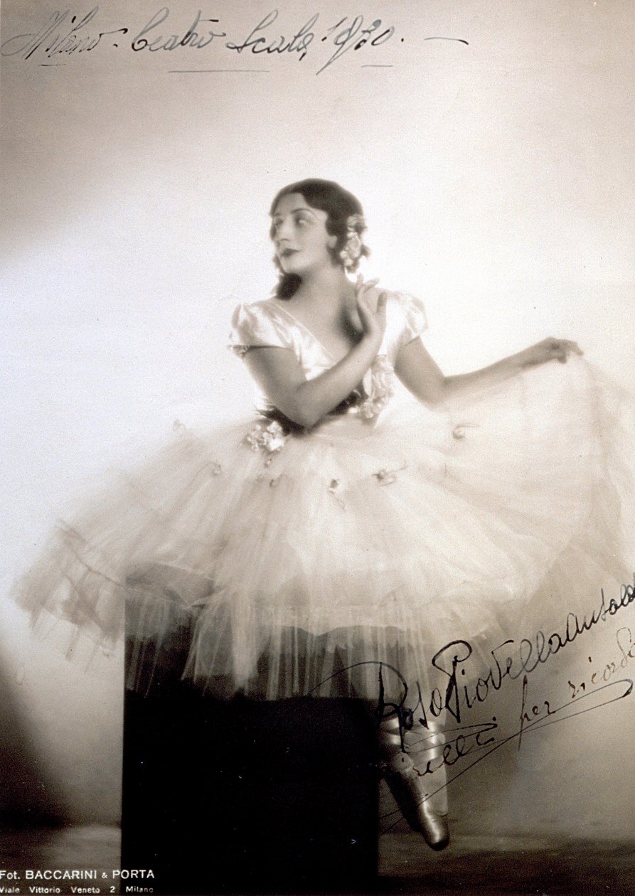 Portrett av den klassiske ballerinaen Rosa Piovella Ansaldo, i tutu og ballettsko. Hun sitter foran, ansiktet vendt til siden. Klutroser dekorerer plagget hennes og nøye kledd hår (Milan, Teatro alla Scala) (s/hv-bilde) av Baccarini and Porta