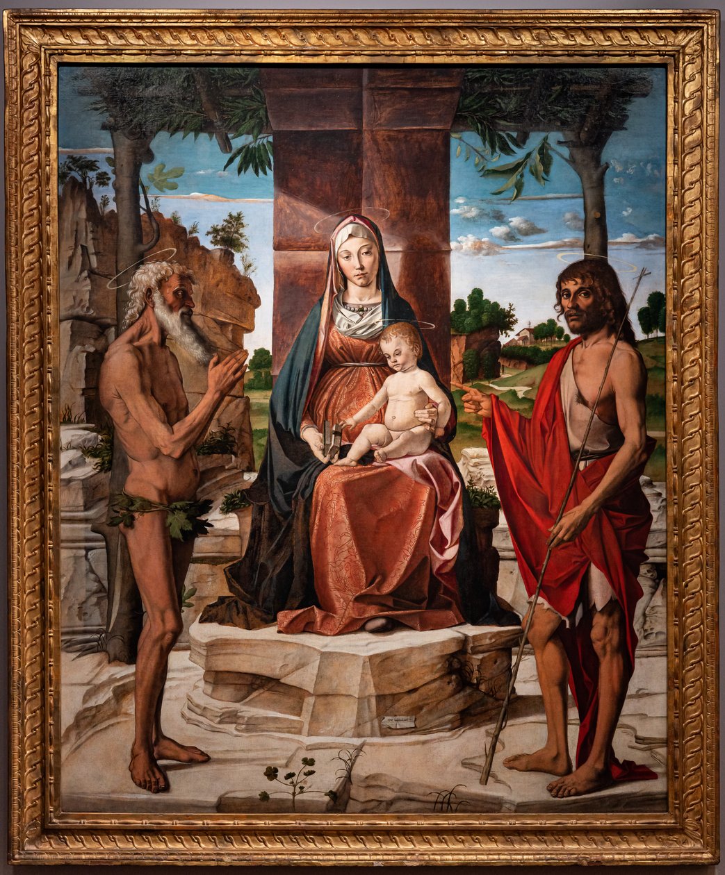 Madonna med spedbarnet Jesus under en pergola blant de hellige døperen Johannes og Onuphriusm 1485-86 (olje på panel) av Bartolomeo Montagna