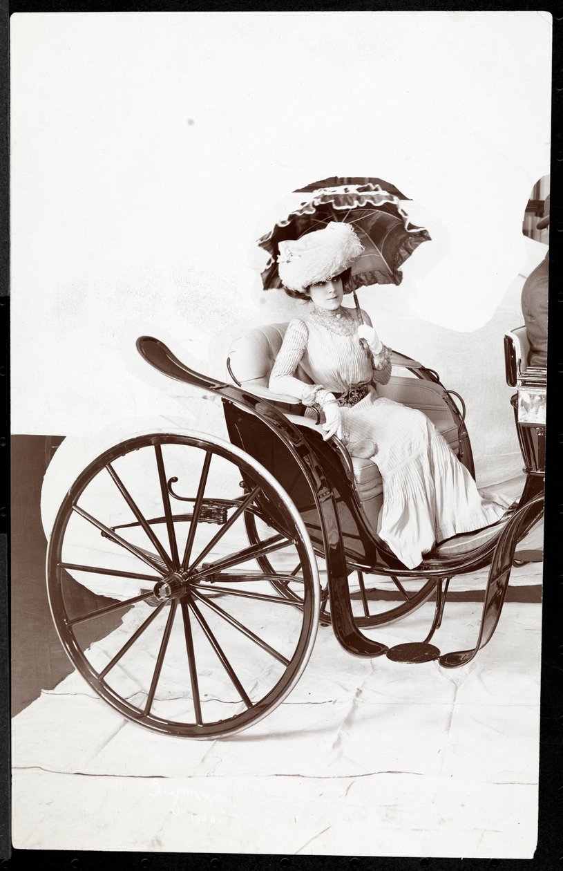 En motemodell sittende i en vogn med en parasoll, 1902 (sølv gelatintrykk) av Byron Company