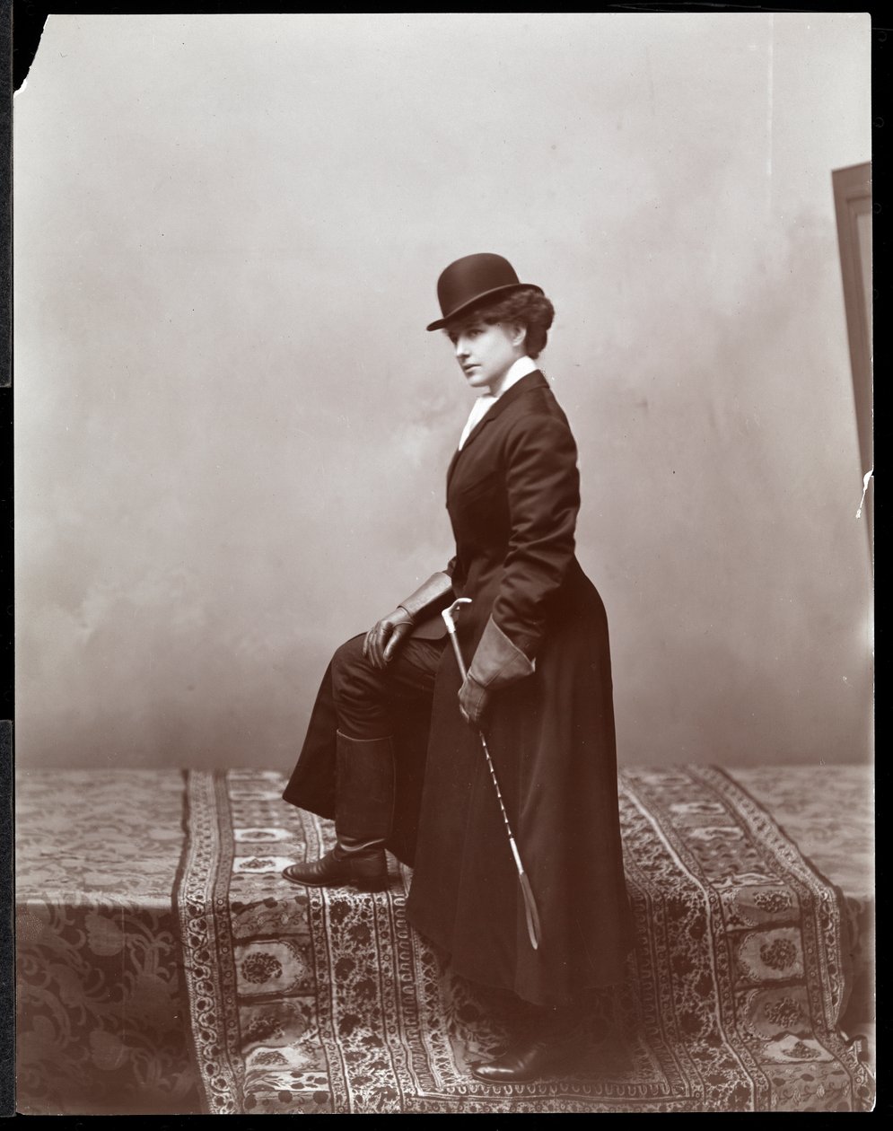 En kvinnelig modell poserer i studioet til illustratøren Malcolm Strauss, ca. 1895 (sølv gelatintrykk) av Byron Company
