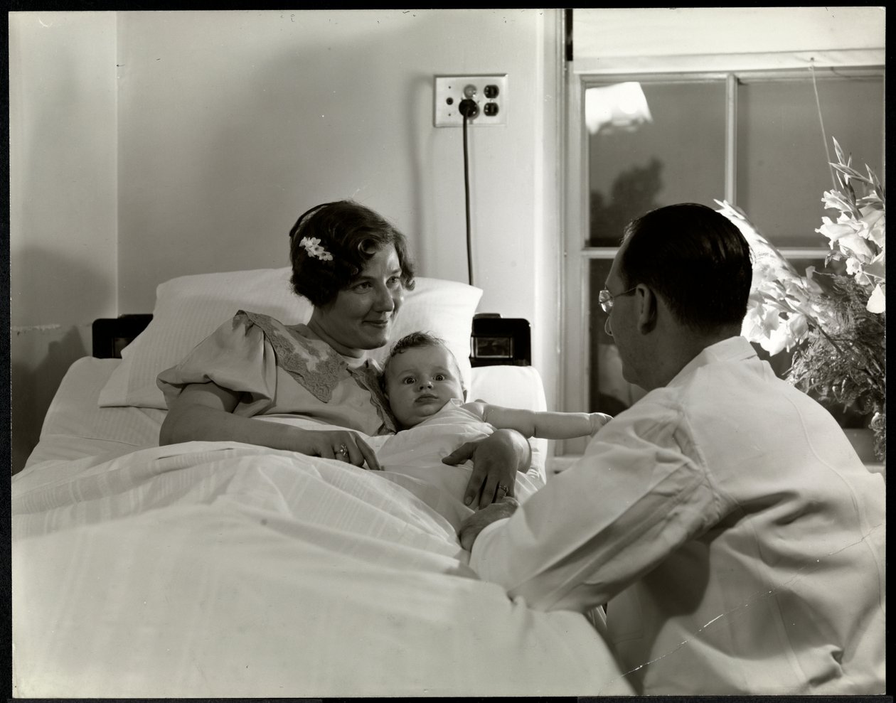 En mor og et barn i en sykehusseng, New York, ca. 1937 (sølv gelatintrykk) av Byron Company