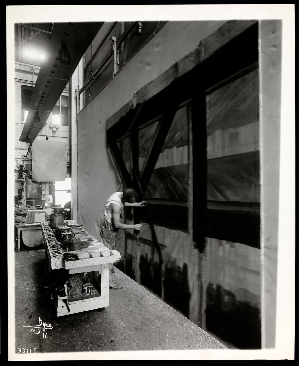 En naturskjønn kunstner som maler en leilighet i en scenebutikk, New York, 1915-6 (sølv gelatintrykk) av Byron Company