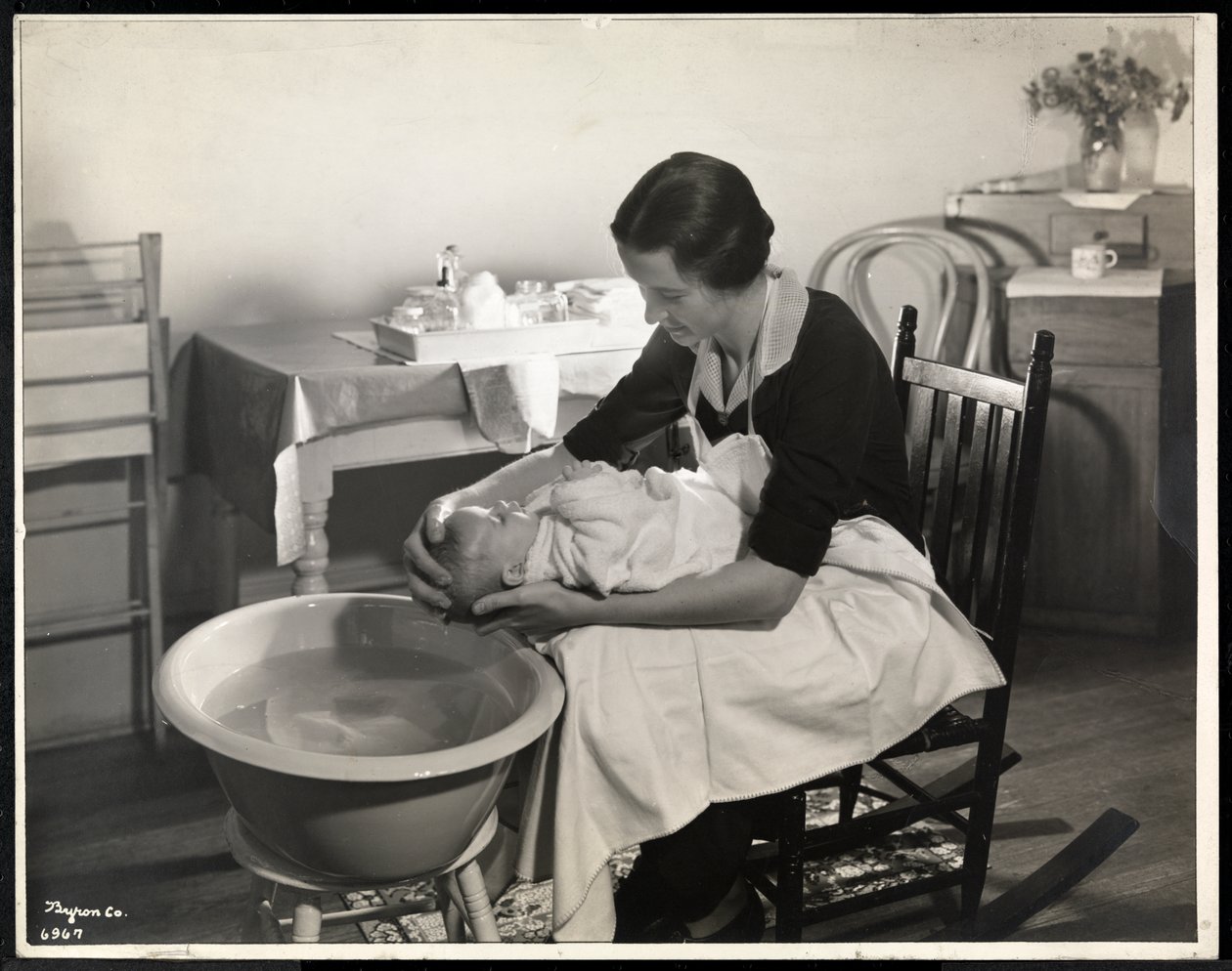 En kvinne som vasker en babys hode ved Maternity Center Association på 211 East 57th Street, New York, 1934 (sølv gelatintrykk) av Byron Company
