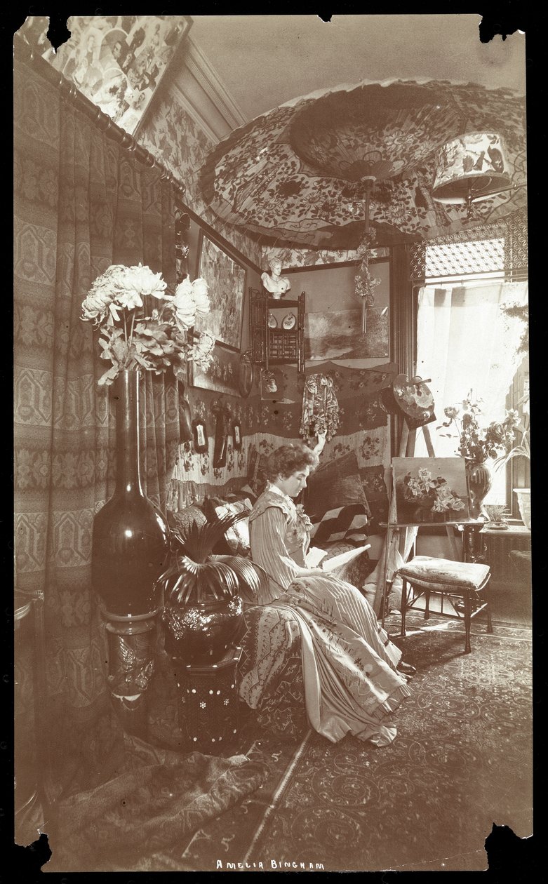 Amelia Bingham sitter i leiligheten sin og leser, ca. 1905 (sølv gelatintrykk) av Byron Company
