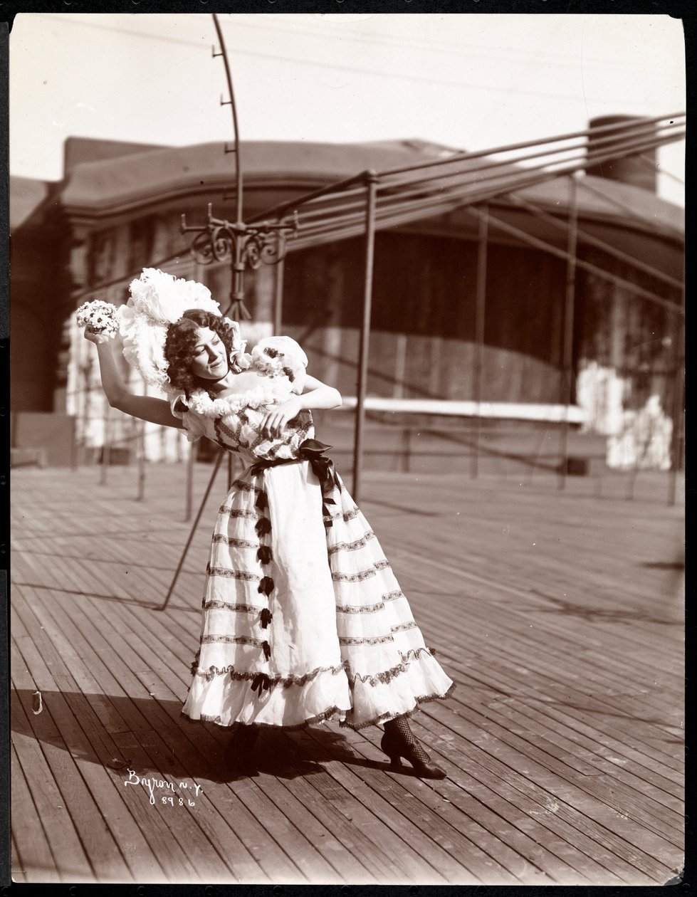 En skuespillerinne i kostyme som øver på taket av det som sannsynligvis er New York Theatre, New York, 1900 (sølv gelatintrykk) av Byron Company