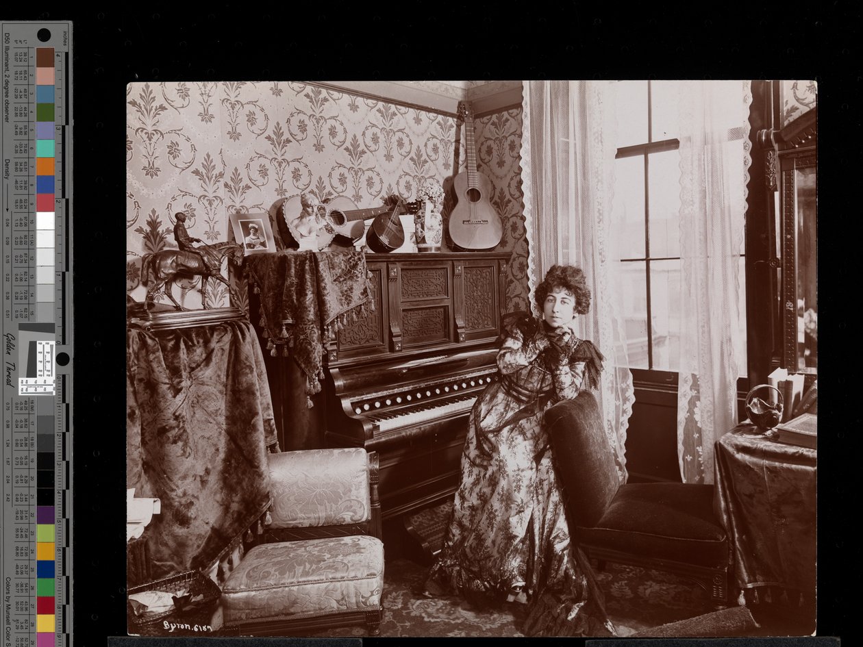 Anita Chartres sitter ved et pianospiller, ca. 1898 (sølv gelatintrykk) av Byron Company