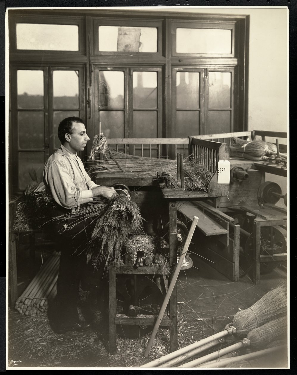 Blind mann fester halm på kosteskafter ved Bourne Memorial Building, New York, 1921 (sølv gelatintrykk) av Byron Company