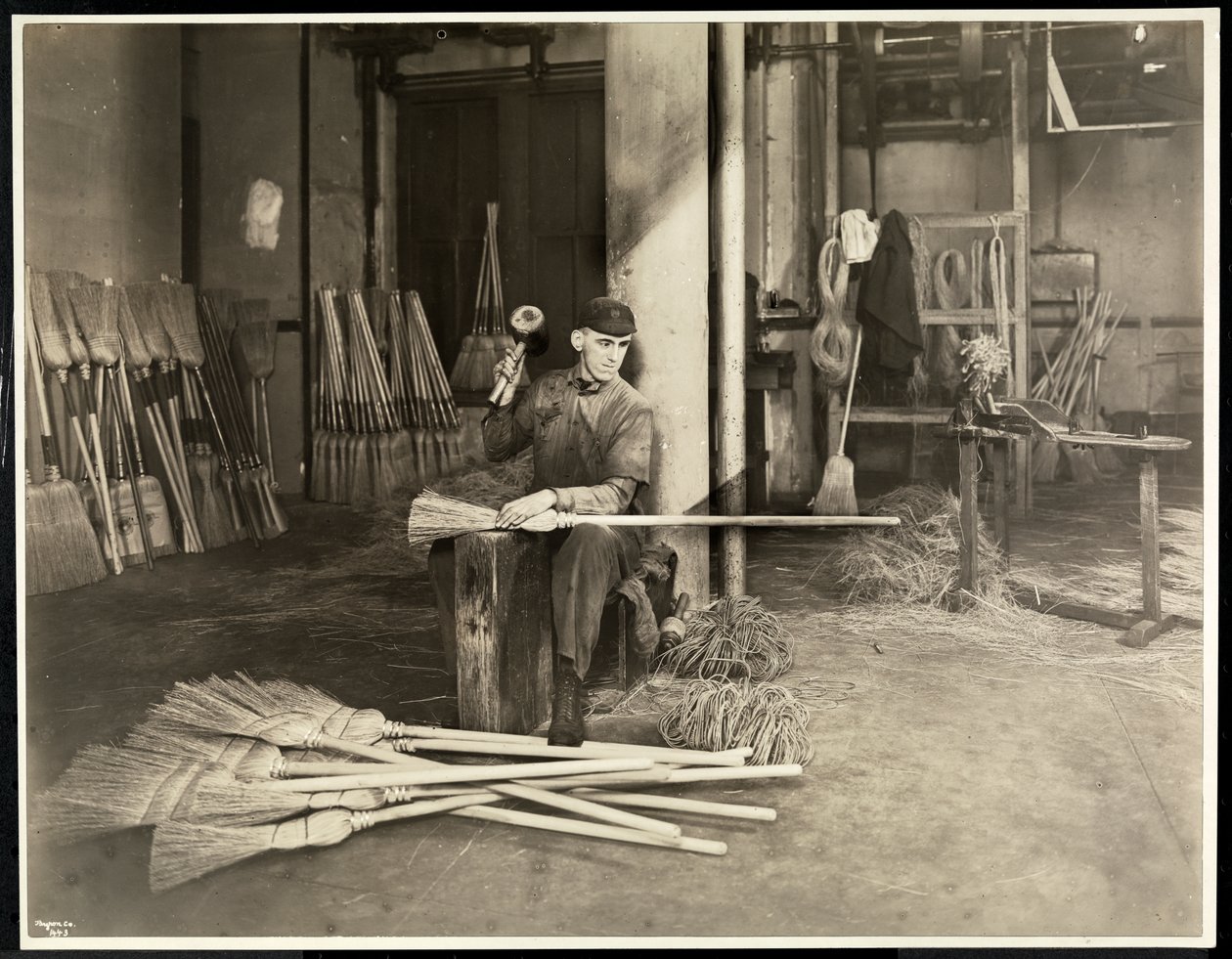 Blind mann som plasserer jernbøyler på koster ved Bourne Memorial Building, New York, 1921 (sølv gelatintrykk) av Byron Company