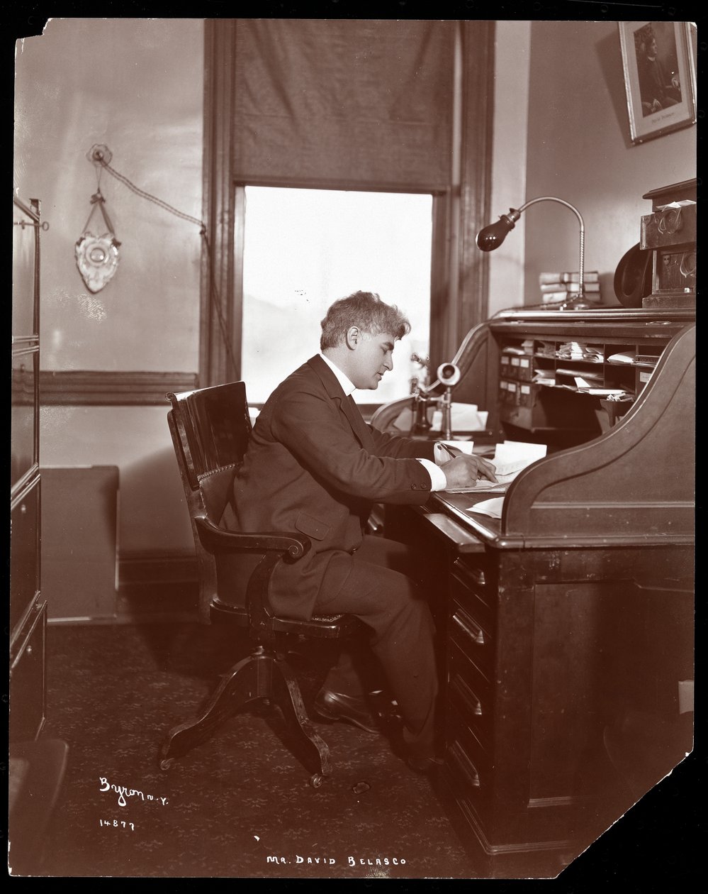 David Belasco skrev ved et skrivebord på kontorene til teateret hans, 1902 (sølv gelatintrykk) av Byron Company