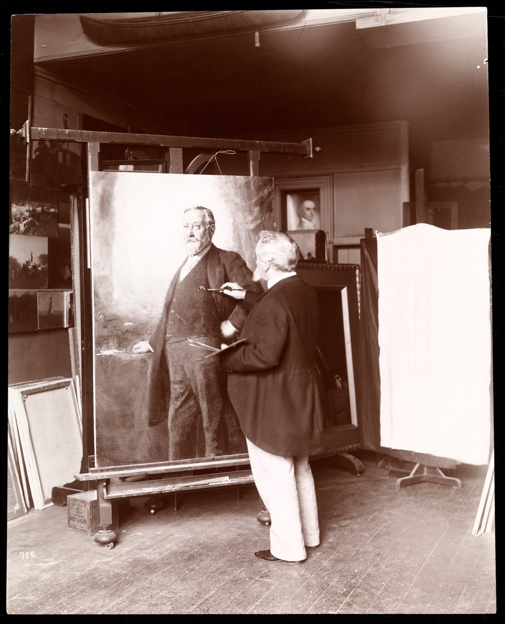 Eastman Johnson med pensel i hånden, jobber med portrett av president Harrison i studioet hans, New York, 1895 (sølvgelatintrykk) av Byron Company