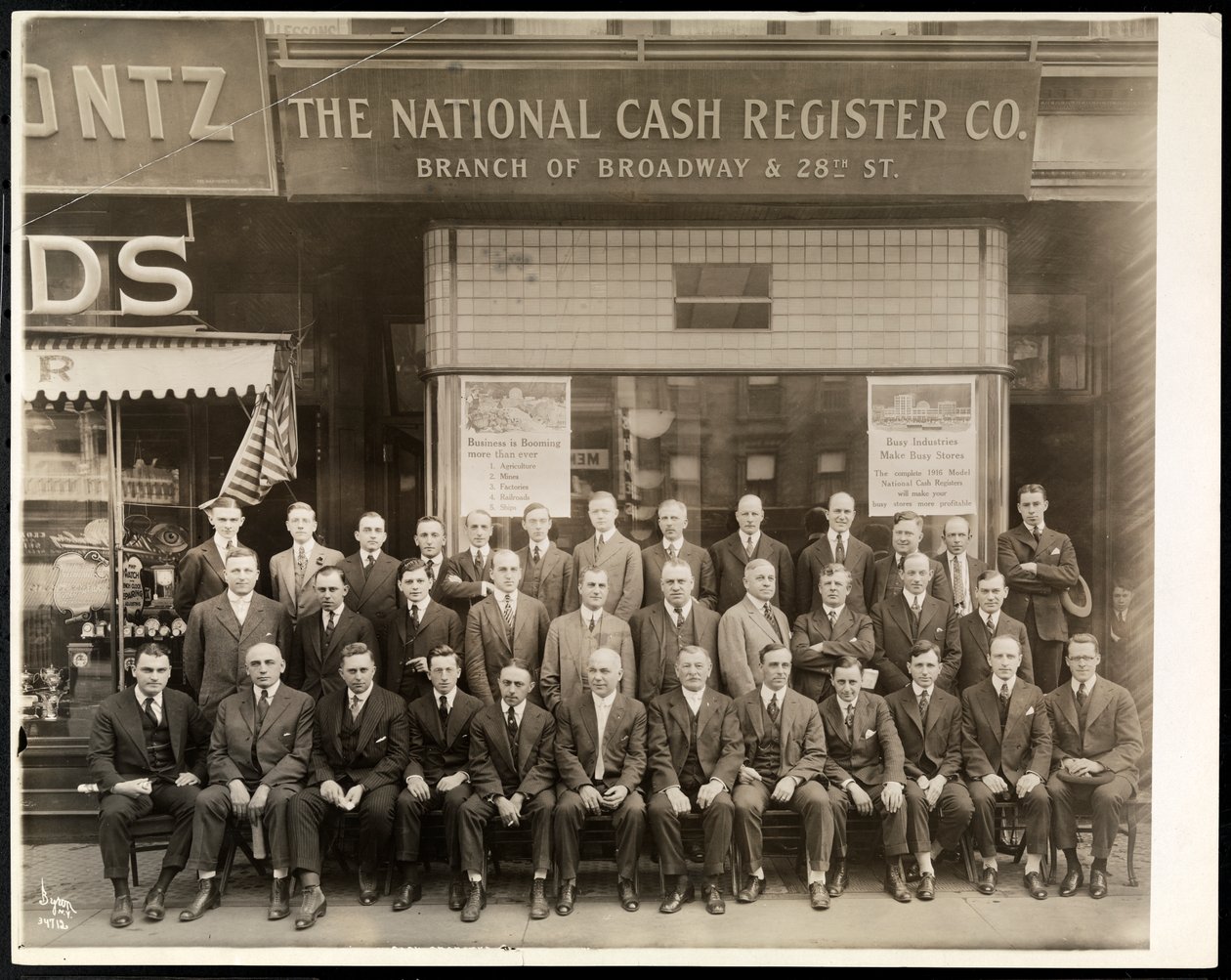 En gruppe menn fra National Cash Register Co. poserte foran Broadway and 28th Street filial, New York, 1916 (sølv gelatintrykk) av Byron Company