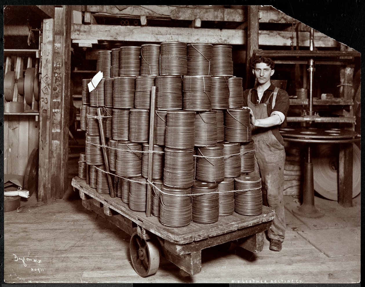 Interiørbilde av en mann som arbeider med skinn ved New York Leather Belting Co., New York, 1906 (sølv gelatintrykk) av Byron Company