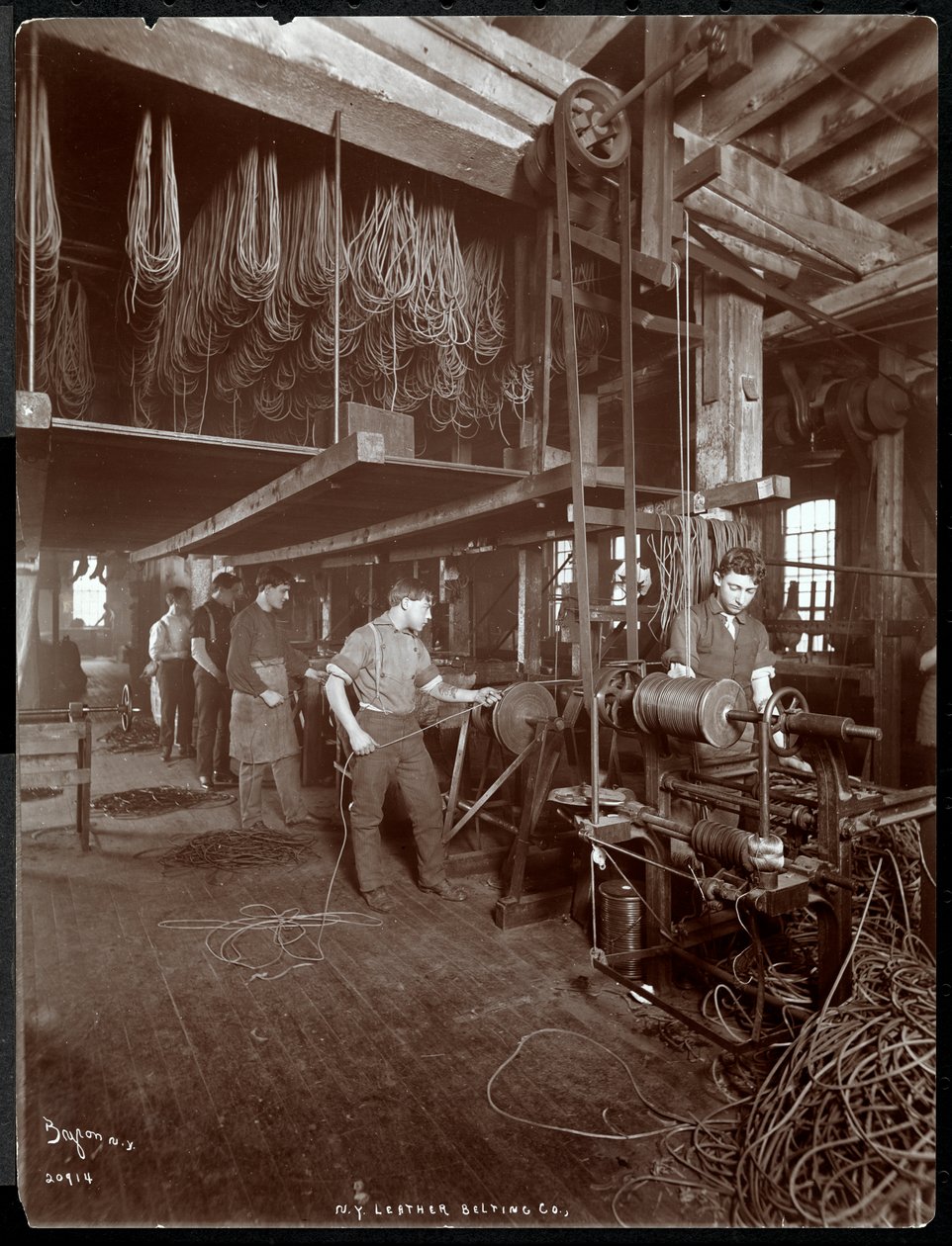 Interiørbilde av en mann som arbeider med skinn ved New York Leather Belting Co., New York, 1906 (sølv gelatintrykk) av Byron Company
