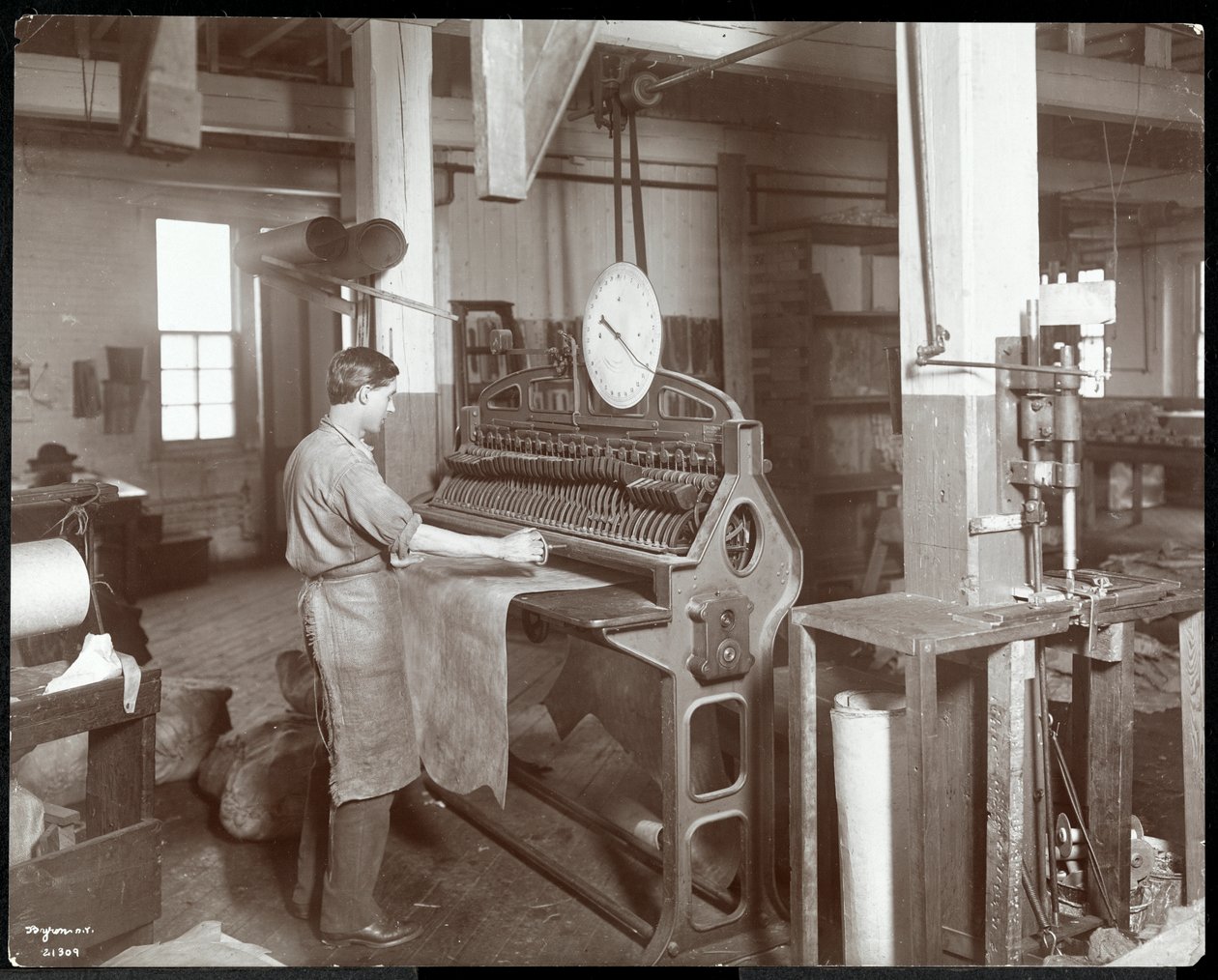 Interiørbilde av en mann som arbeider med skinn ved New York Leather Belting Co., New York, 1906 (sølv gelatintrykk) av Byron Company