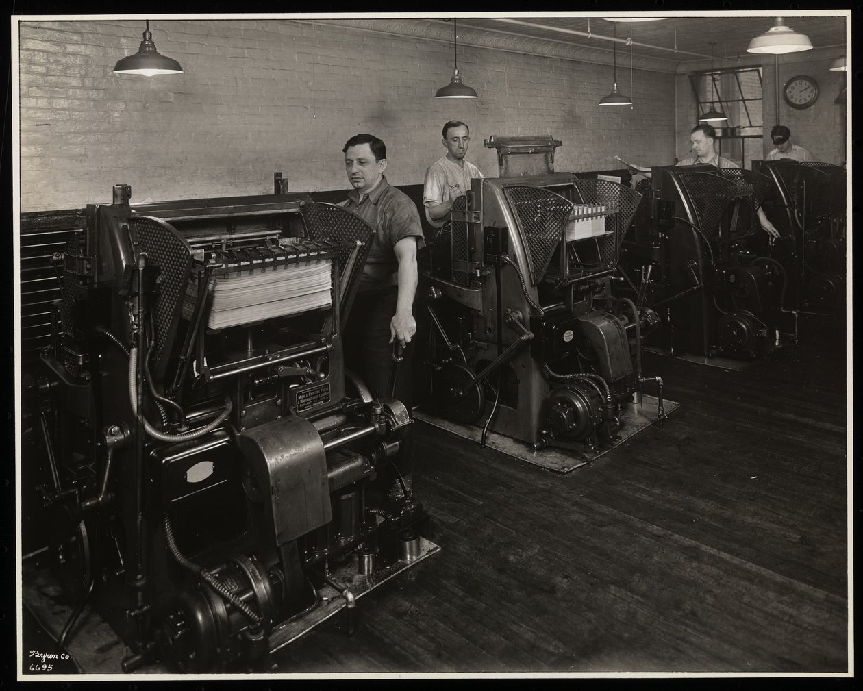 Menn som jobber med trykkpresser i Unz und Co., 24 Beaver Street, New York, 1932 (sølv gelatintrykk) av Byron Company