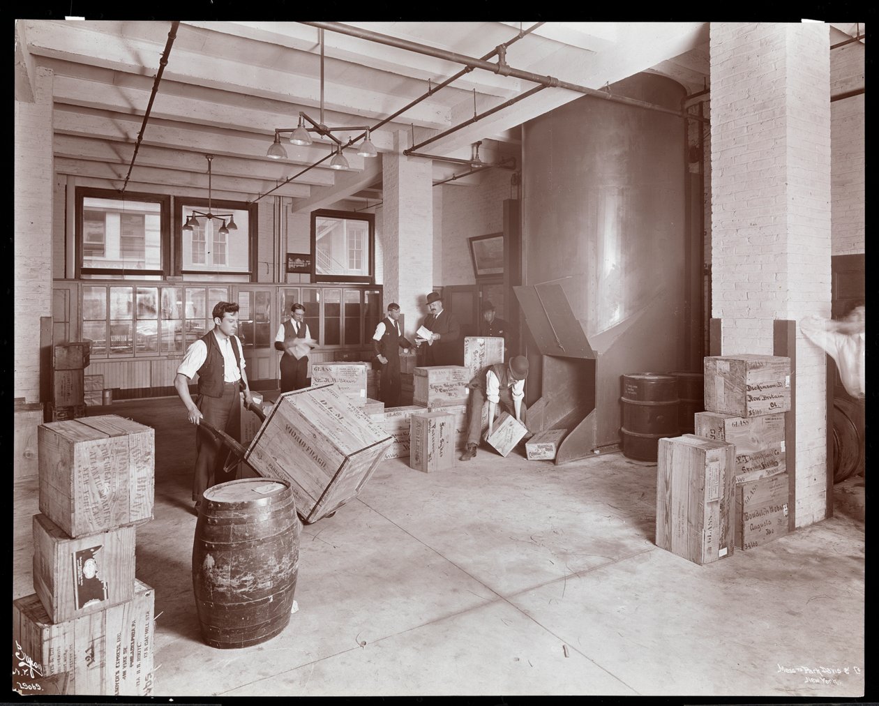 Menn som jobber med kasser i fraktavdelingen i Parke, Davis und Co., kjemikere, Hudson und Vestry Streets, New York, 1910 (sølvgelatintrykk) av Byron Company