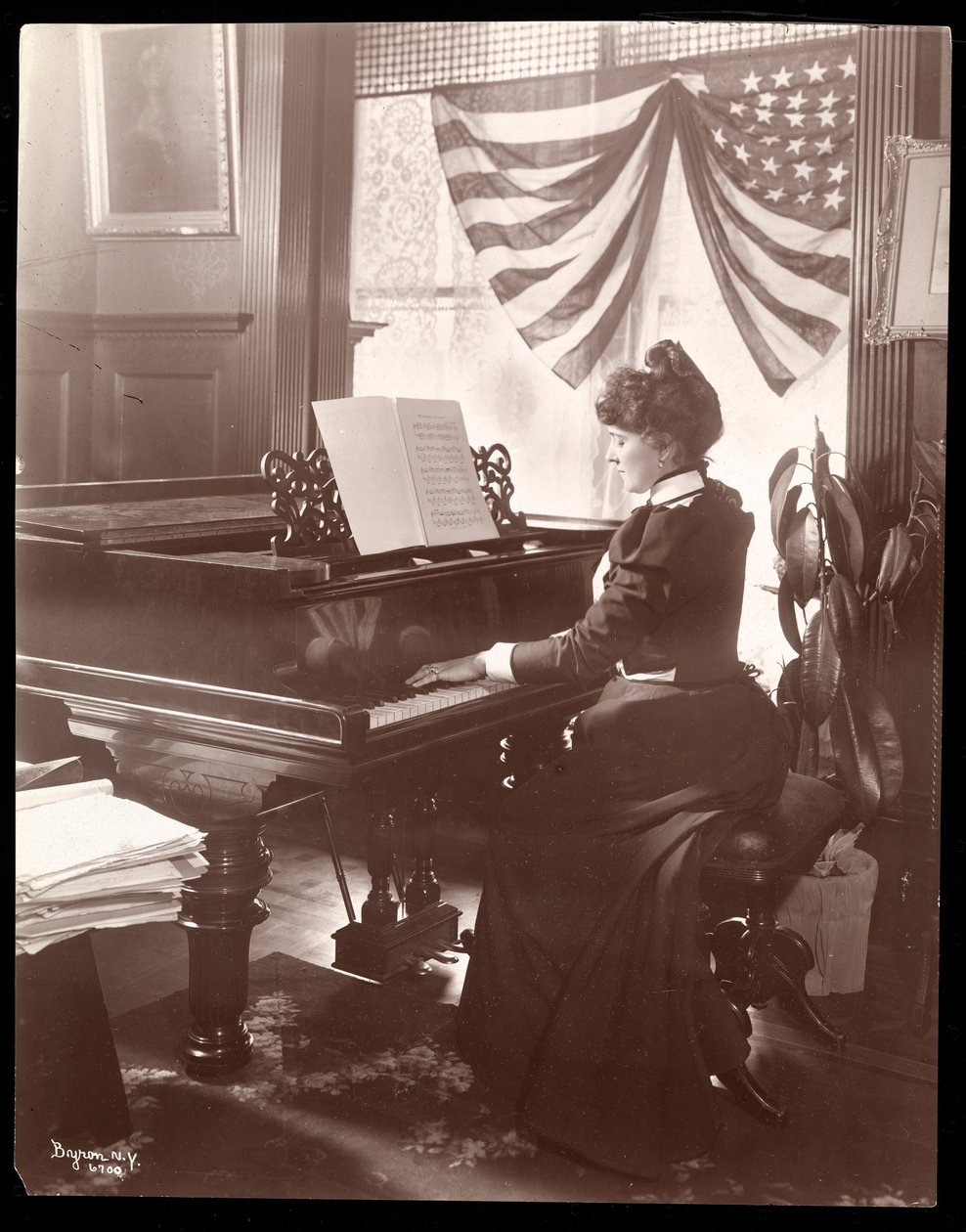 Fru Florence Clinton Sutro spiller piano i hjemmet sitt på 320 West 102nd Street, New York, 1899 (sølv gelatintrykk) av Byron Company