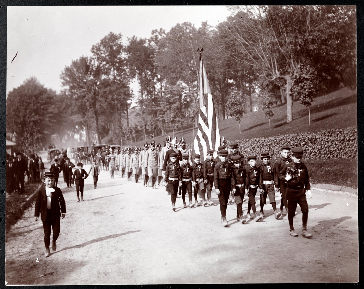 Parade med barn og brannmenn som marsjerer i Dobbs Ferry, New York, 1898 (sølv gelatintrykk) av Byron Company