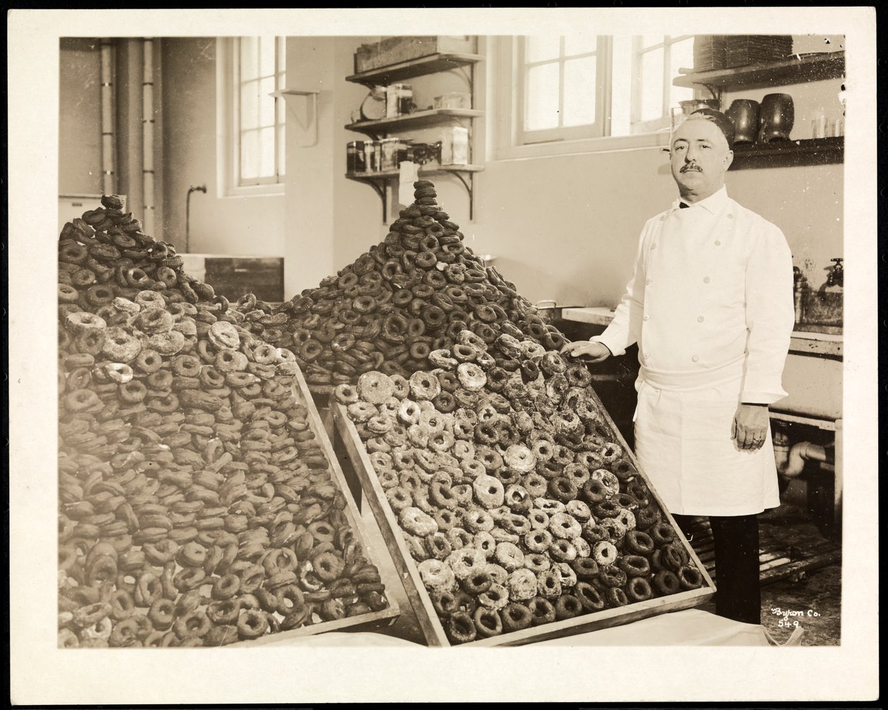 Portrett av kokk Leoni med binger med smultringer for Frelsesarmeen på Hotel Commodore, 1919 (sølv gelatintrykk) av Byron Company