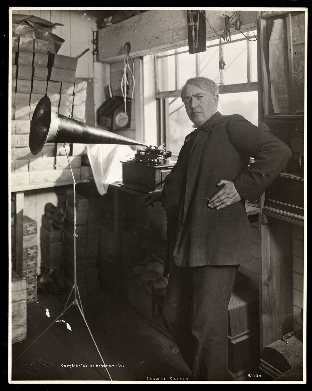 Thomas Edison står ved siden av en fonograf i laboratoriet hans, 1920 (sølv gelatintrykk) av Byron Company