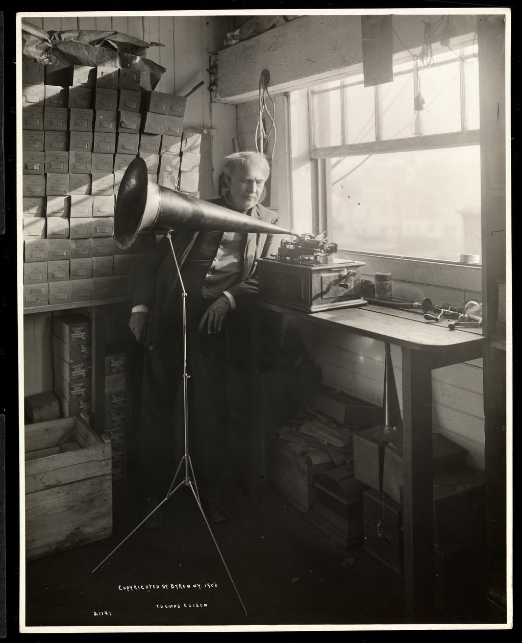 Thomas Edison står ved siden av en fonograf i laboratoriet hans, 1920 (sølv gelatintrykk) av Byron Company