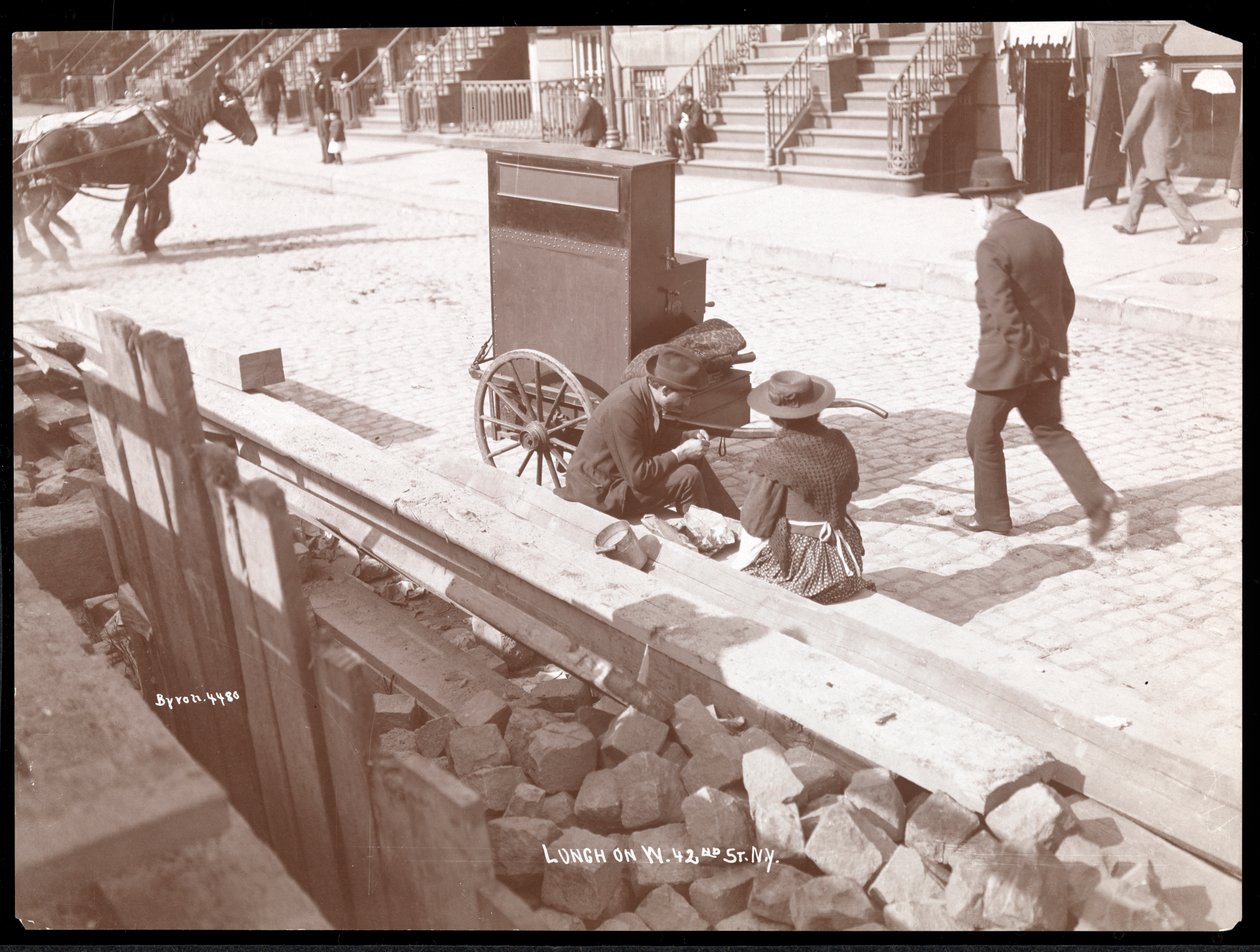 Utsikt over en gateorganist og en kvinne som spiser lunsj på West 42nd Street, New York, 1898 (sølv gelatintrykk) av Byron Company