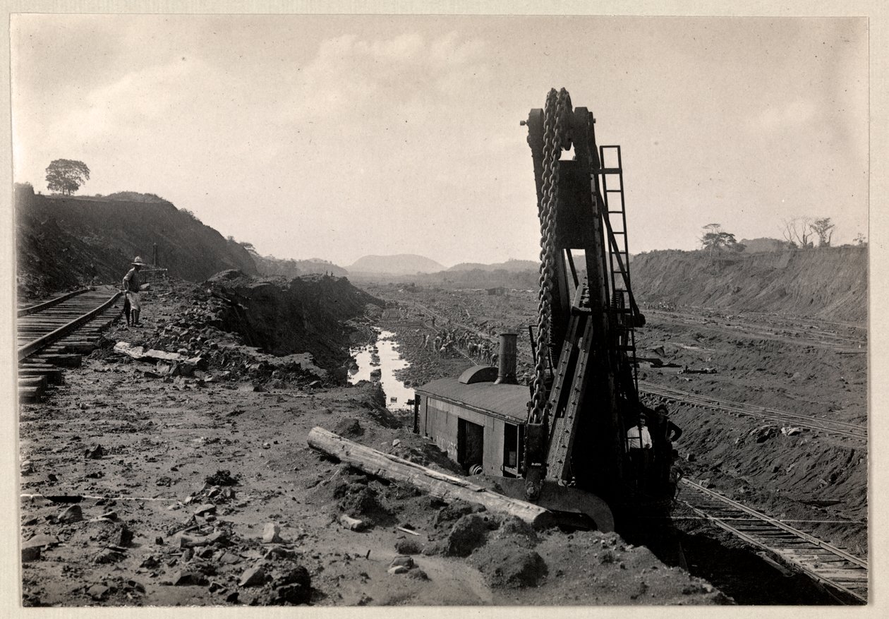 Utsikt over arbeidere som graver Panamakanalen med jernbanespor gjennom en grøft og en slags gravemaskin i forgrunnen, 1912 eller 1913 (sølvgelatintrykk) av Byron Company