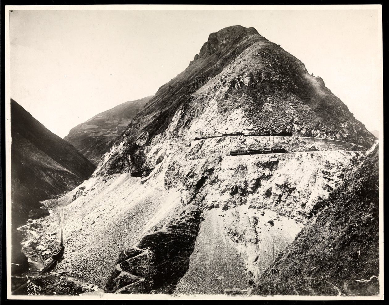 Utsikt over to jernbanetog på spor langs et fjell, antagelig på eller i nærheten av Panamakanalen, 1912 eller 1913 (sølv gelatintrykk) av Byron Company