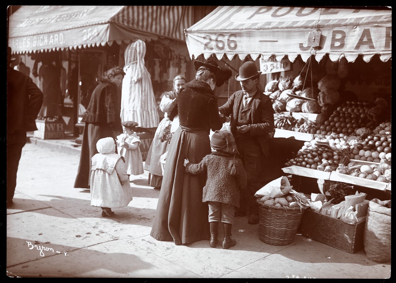Utsikt over kvinner med barn som handler på en frukt- og grønnsaksbod på 266 7th Avenue, New York, ca. 1900 (sølv gelatintrykk) av Byron Company